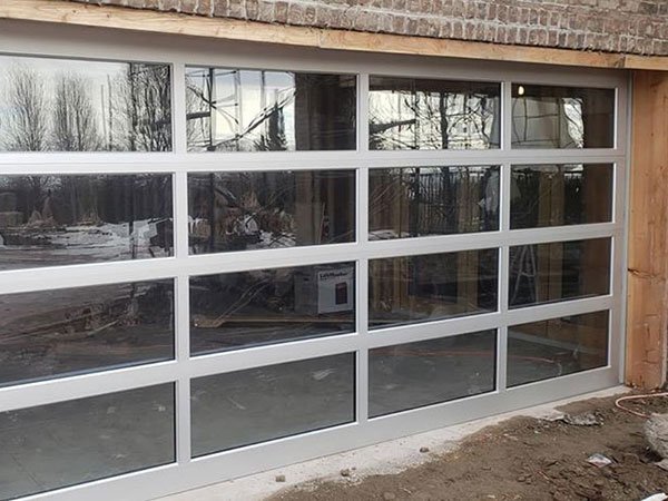 Outside view of a newly-installed residential garage door with glass panels