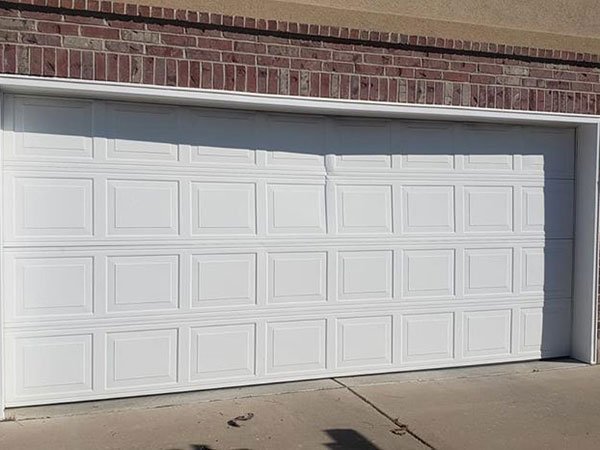 A white 16 feet by 7 feet double garage door made of white panels