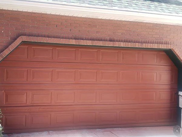 Outside view of a garage with brick façade and a wooden garage door