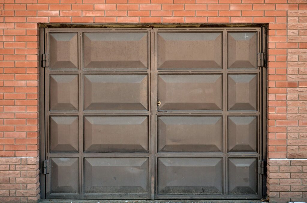a brown metal gate against a brick wall
